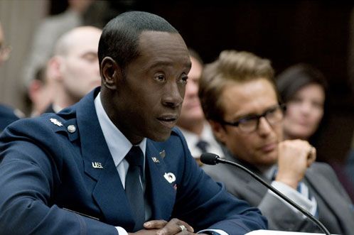 James 'Rhodey' Rodes (Don Cheadle) declarando en un juicio con Justin Hammer (Sam Rockwell) al fondo